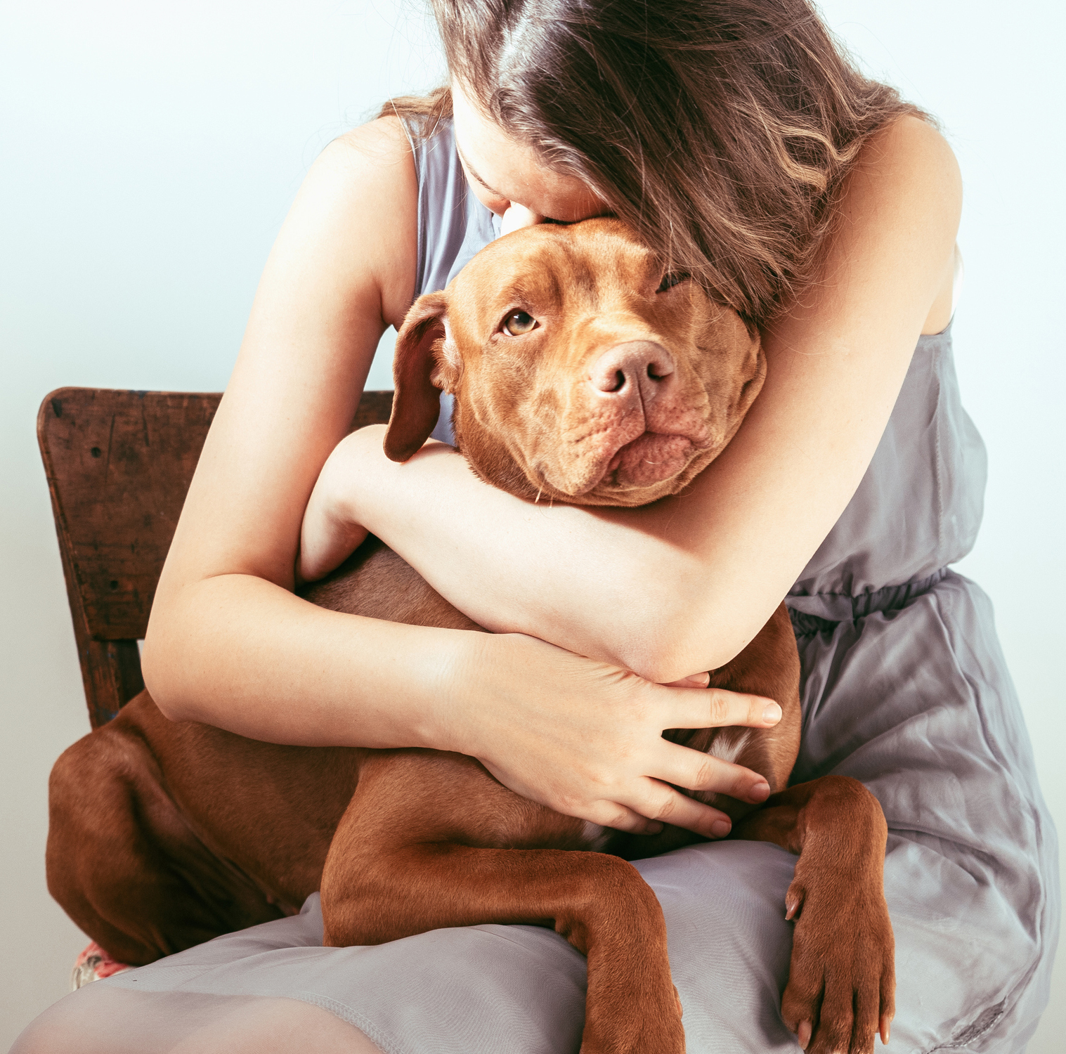 woman hugging brown dog