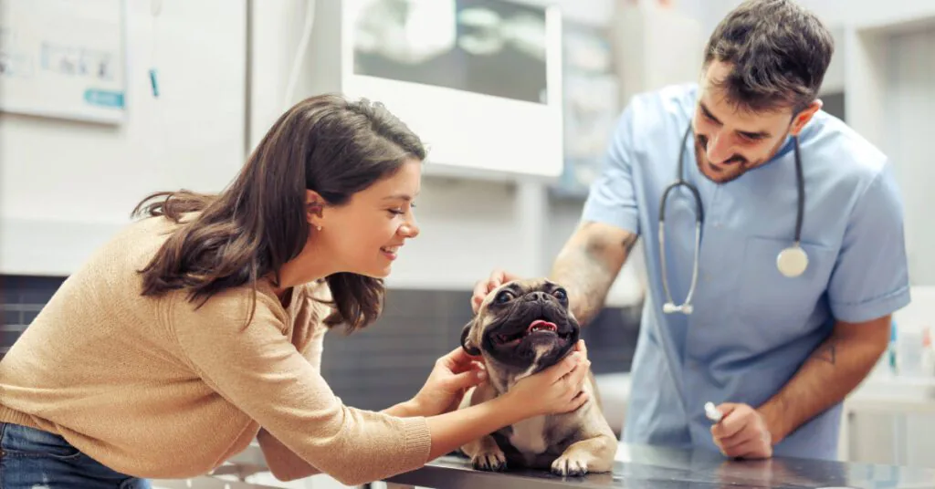 female owner petting dog during vet appointment